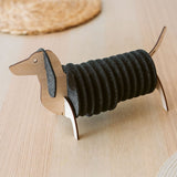 A napkin holder shaped like a dachshund dog, made of wood with black felt napkins forming the dog's body, sits on a light wooden table—perfect for pairing with matching felt coasters or Dachshund coasters for a charming tablescape.
