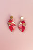 A pair of gold and pink Anatomical Heart Earrings, crafted in acrylic with detailed vein patterns and a unique style, displayed on a light pink background.